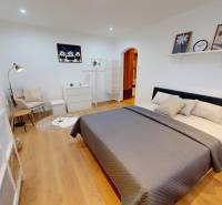 Schlafzimmer in einer Einzimmerwohnung mit Bett, Sessel und Dekorationen.