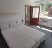 Helles Zimmer mit Bett, Nachttisch und Fenster, geeignet für eine 2-Zimmer-Wohnung.
