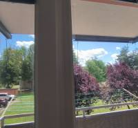 Blick vom Balkon in einer 2-Zimmer-Wohnung in Liptovský Mikuláš, Bäume und geparkte Autos.