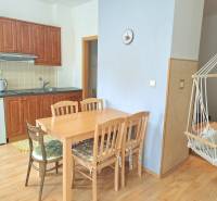 Küche mit Einbauschränken, Esstisch und Schaukelstuhl in einer 3-Zimmer-Wohnung.
