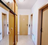 Diele in einer 3-Zimmer-Wohnung mit eingebauten Holzschränken und Keramikfliesen.