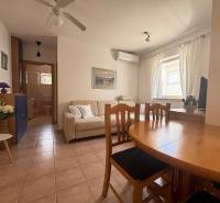 Wohnzimmer in einer Zweizimmerwohnung mit Esstisch, Sofa und Klimaanlage.
