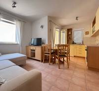Obývačka in einer 2-Zimmer-Wohnung mit Küchenzeile, Sofa und Esstisch.