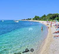 Der Strand in Novalja mit Touristen, die sich am Meer entspannen.
