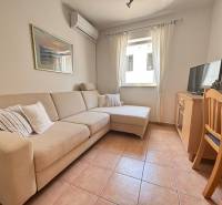 Wohnzimmer mit Sofa, Klimaanlage, Fernseher und Esstisch in einer 2-Zimmer-Wohnung.