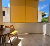 Balkon einer 2-Zimmer-Wohnung in Novalja mit Holztisch und grünem Ausblick.