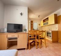Küche mit Essbereich in einer 2-Zimmer-Wohnung, eingerichtet mit Holzmöbeln und Geräten.