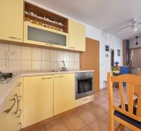 Küche in einer 2-Zimmer-Wohnung mit Holzmöbeln und eingebauten Geräten.
