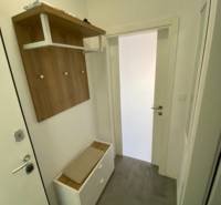 Der Flur einer 2-Zimmer-Wohnung mit Garderobe, Schuhschrank und weißen Wänden.