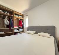 Schlafzimmer mit Doppelbett und Kleiderschrank in einer 2-Zimmer-Wohnung.