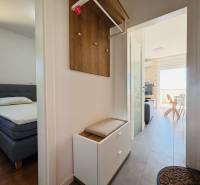 Der Flur, der zum Schlafzimmer und Wohnzimmer in einer 2-Zimmer-Wohnung mit hellen Möbeln führt.
