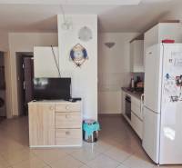 Küche in einer 2-Zimmer-Wohnung mit Geräten, Schrank, Fernseher und Wanddekoration.