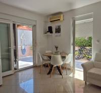 Innenraum einer 2-Zimmer-Wohnung mit Esstisch, Sofa und Zugang zur Terrasse.