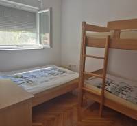 Schlafzimmer in einer 2-Zimmer-Wohnung mit einem Etagenbett und einem Einzelbett.