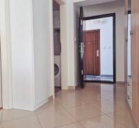 Flur in einer 2-Zimmer-Wohnung mit Waschmaschine und Eingangstür.