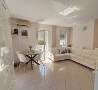 Helles Wohnzimmer in einer 2-Zimmer-Wohnung mit weißem Sofa und Esstisch.