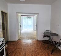 Küche in einer 2-Zimmer-Wohnung mit Esstisch, Fliesen und Zugang zum Wohnzimmer.