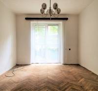 Ein Zimmer in einer 2-Zimmer-Wohnung mit Holzboden und Kronleuchter.