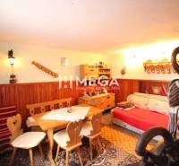 Hütte mit stilvollen Möbeln und Dekorationen. Holz, Sofa, Tisch, Lampen, warme Atmosphäre.