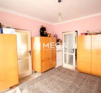 Ein Zimmer in einer 2-Zimmer-Wohnung mit Holzschränken und rosa Wänden.