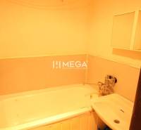 Badezimmer mit Badewanne und Waschbecken in einer 2-Zimmer-Wohnung, einfaches Interieur.