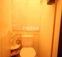 Toilette in einer 2-Zimmer-Wohnung mit Fliesenboden und Stauraum für Toilettenartikel.