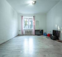 Ein geräumiges Zimmer in einer 3-Zimmer-Wohnung mit Laminatboden und Fernseher.