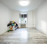 Ein geräumiges Zimmer mit einem Einzelbett und einem großen Fenster in einer 3-Zimmer-Wohnung.