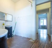 Badezimmer in einer 3-Zimmer-Wohnung mit Spiegel, Badewanne und Ausgang in den Raum.