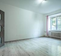 Ein heller Raum mit Holzboden und einem Fenster in einer 3-Zimmer-Wohnung.