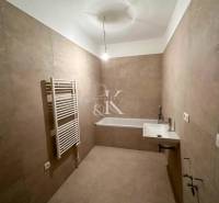 Badezimmer in einer 3-Zimmer-Wohnung mit Waschbecken, Badewanne und Röhrenheizkörper.