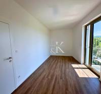 Ein Zimmer mit Holzboden und großem Fenster in einer 3-Zimmer-Wohnung.