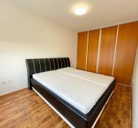 Schlafzimmer mit großem Bett und Einbauschrank in einer 2-Zimmer-Wohnung.
