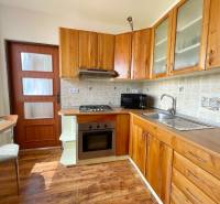 Küche in einer 2-Zimmer-Wohnung mit Holzschränken und Geräten.