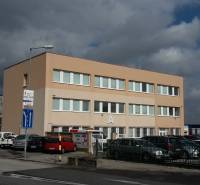 Ein Bürogebäude in der Pestovateľská Straße in Bratislava - Ružinov unter einem bewölkten Himmel.