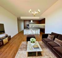 Wohnzimmer in einer Zweizimmerwohnung mit Sofa, Fernseher und Essecke.