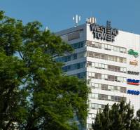 Das Westend Tower-Gebäude zwischen den Bäumen an der Dúbravská-Straße in Bratislava - Karlova Ves.
