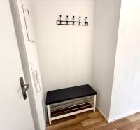 Eingangsflur in einer 2-Zimmer-Wohnung mit Bank und Wandgarderobe.