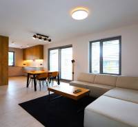 Wohnzimmer mit Küche, Esstisch, Sofa und Holzelemente in einem Einfamilienhaus.