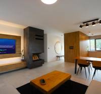 Wohnzimmer in einem Einfamilienhaus mit Kamin, Fernseher und Essecke.