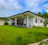 Ein Einfamilienhaus in Piešťany mit einer verglasten Terrasse und einem grünen Rasen.