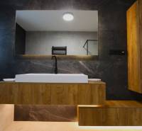 Badezimmer mit Waschbecken und Holzschrank in einem Einfamilienhaus.