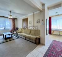 Wohnzimmer in einem Einfamilienhaus mit Sofa, Couchtisch und Teppichen.
