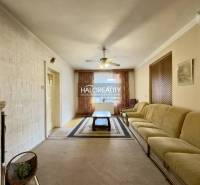 Wohnzimmer mit großem Sofa und Kachelofen in einem Einfamilienhaus.