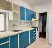 Eine Küche mit blauen Schränken und weißen Geräten in einem Einfamilienhaus.
