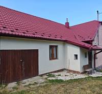 Ein Einfamilienhaus in der Dlha-Straße in Vranov nad Topľou mit einem roten Dach und zwei Türen.