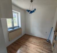 Ein Zimmer mit einem blauen Flugzeug-Luster, Holzboden und Fenster in einem Einfamilienhaus.