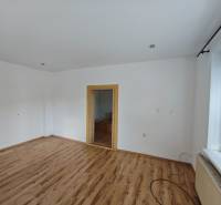Innenraum eines Einfamilienhauses mit Holzboden und zwei Türen.