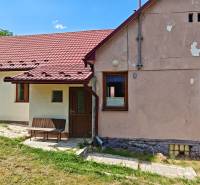 Ein Einfamilienhaus in der Dlhá-Straße in Vranov nad Topľou mit einem roten Dach und einer Bank.