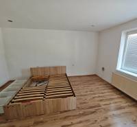 Schlafzimmer mit Bett und Laminatboden in einem Einfamilienhaus.